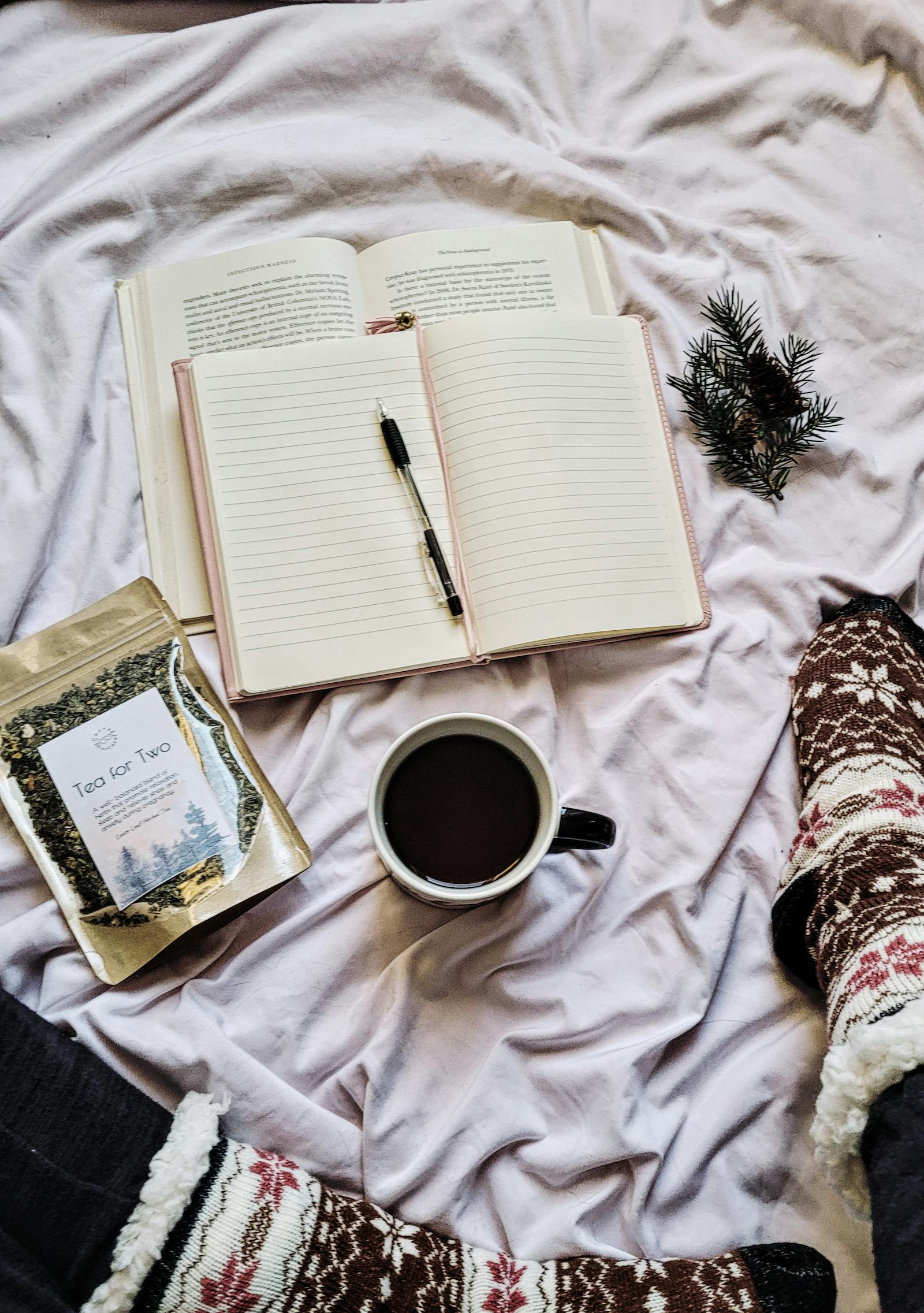 Open journal with a pen, tea, and cozy socks on a soft blanket, evoking integration and reflection during the afterglow