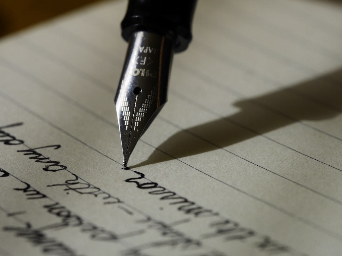 Close-up of a fountain pen writing on lined paper