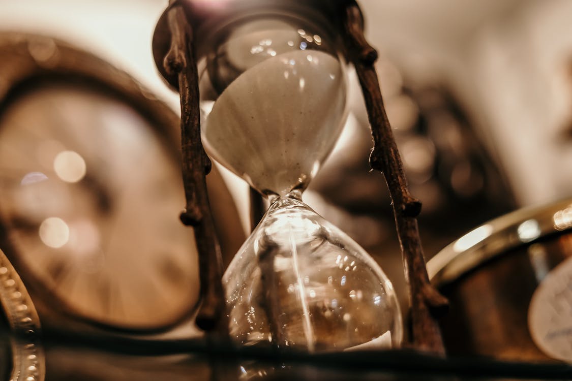Vintage hourglass with sand flowing representing the patience required before a psilocybin experience