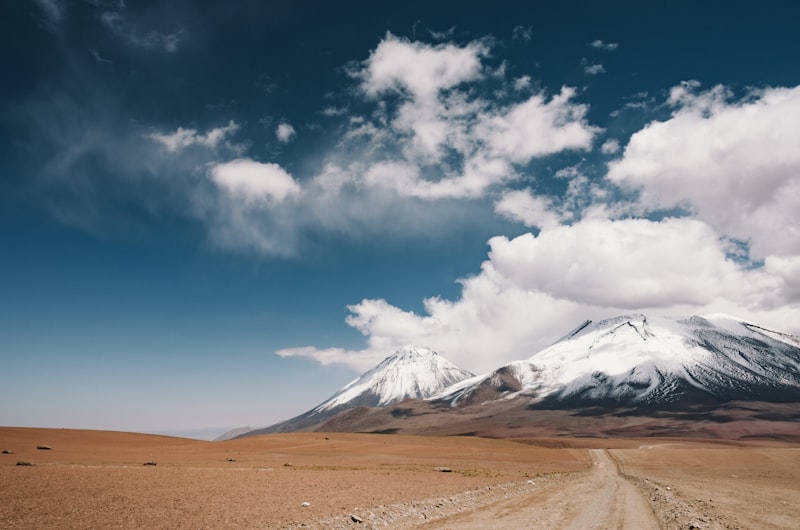 Empty road stretching toward distant mountains at sunset